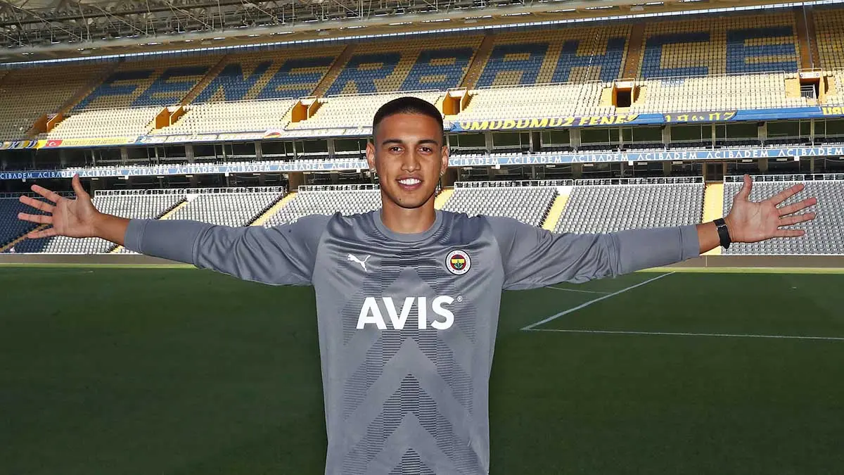 Irfan Can Egribayat in a Fenerbahce jersey posing in a stadium.