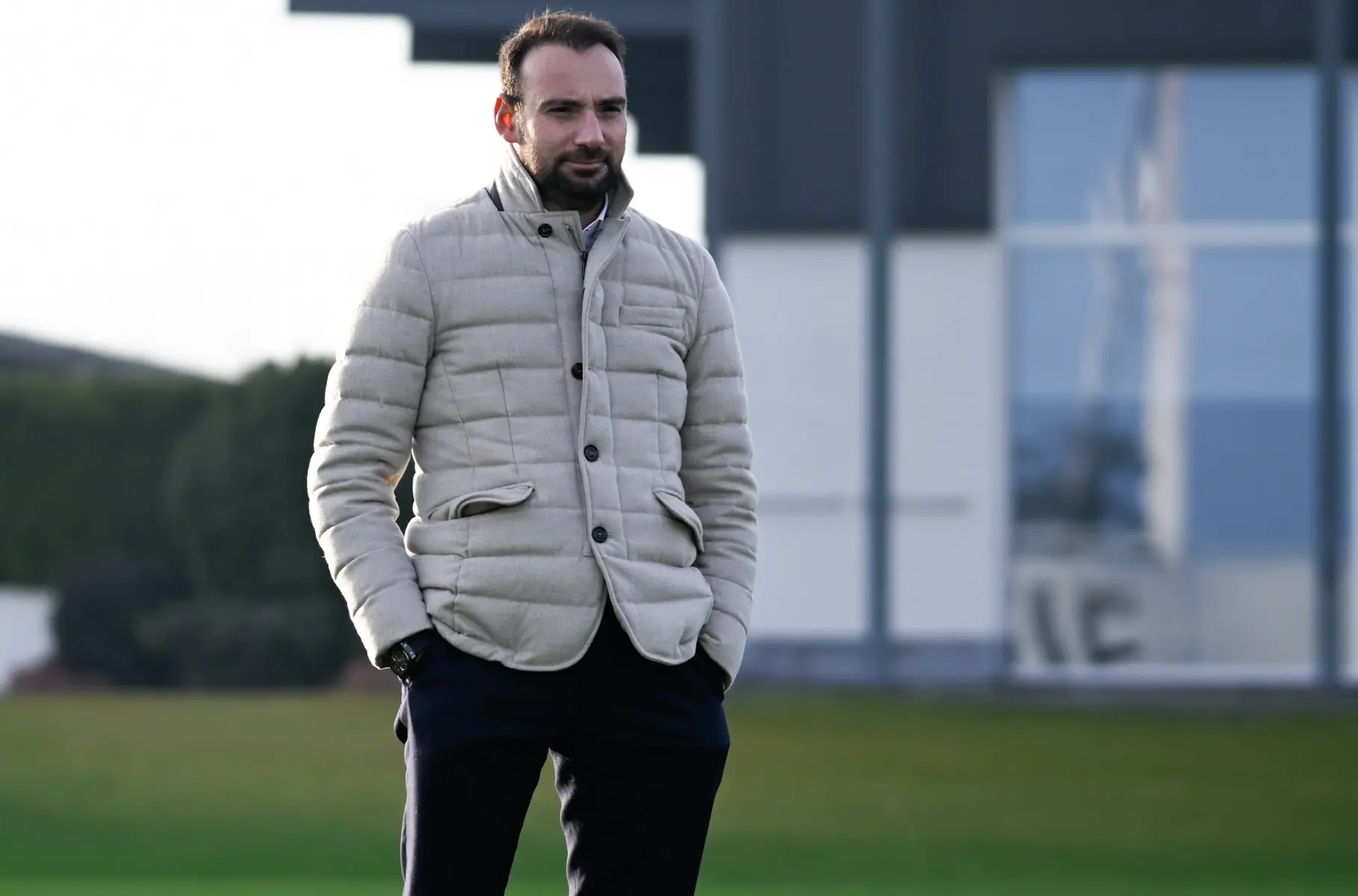 Giovanni Manna standing outdoors in a light beige quilted jacket and dark trousers