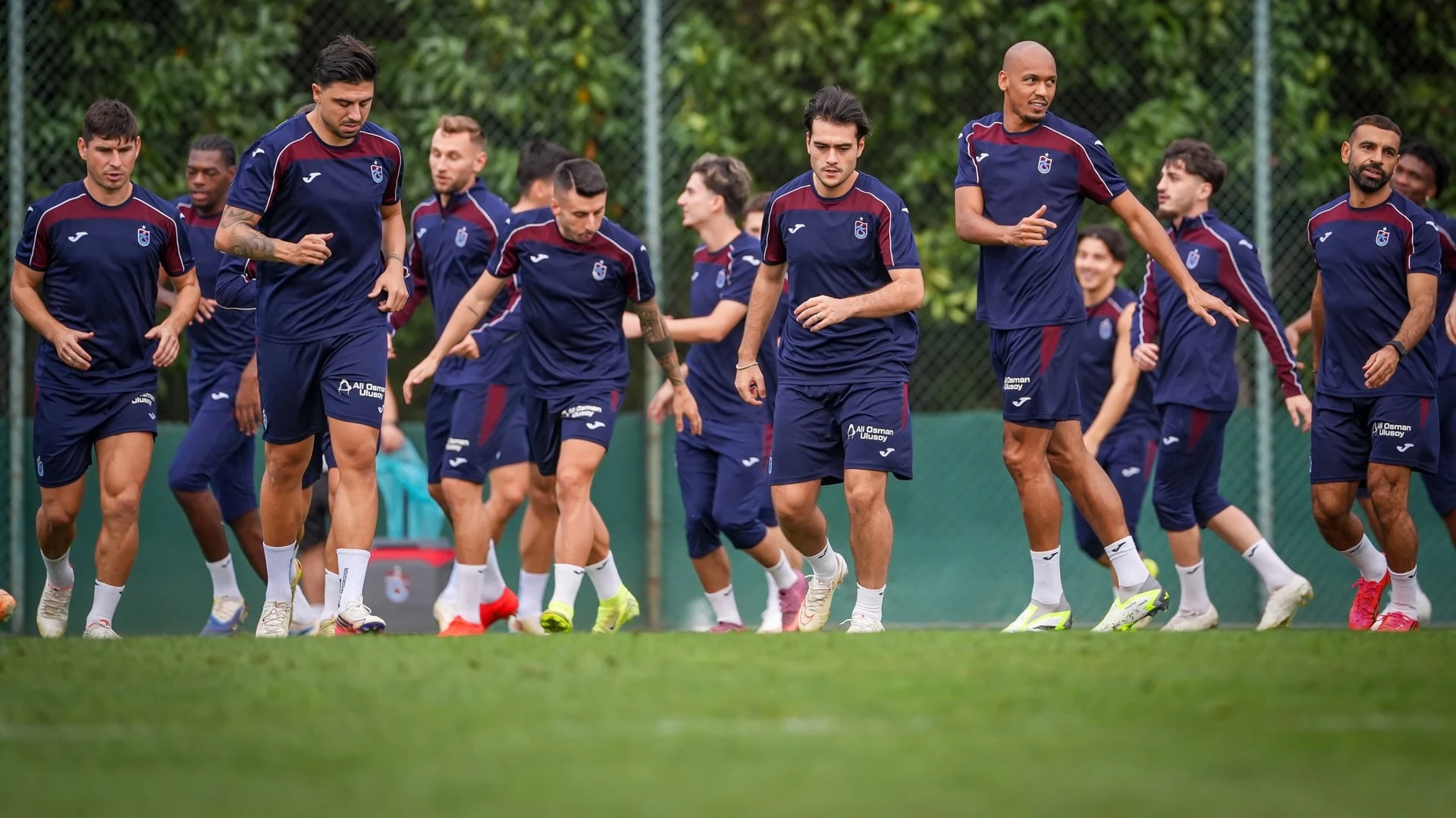 Trabzonspor futbolcuları antrenman sırasında sahada koşuyor.